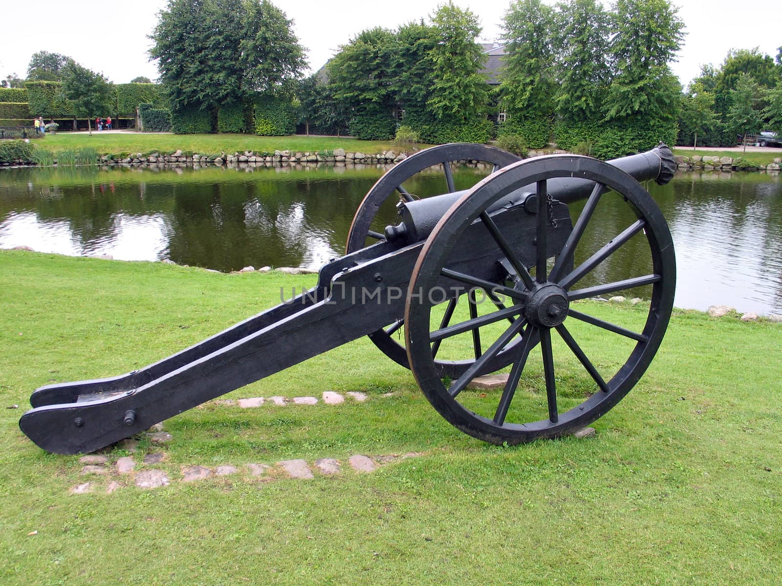 Old cannon by a water canal at Egeskov Castle Denmark