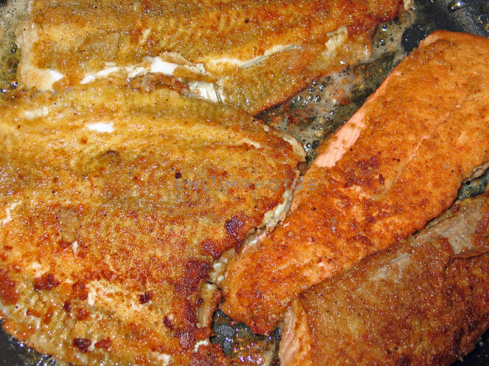 Frying plaice fish in a frying pan