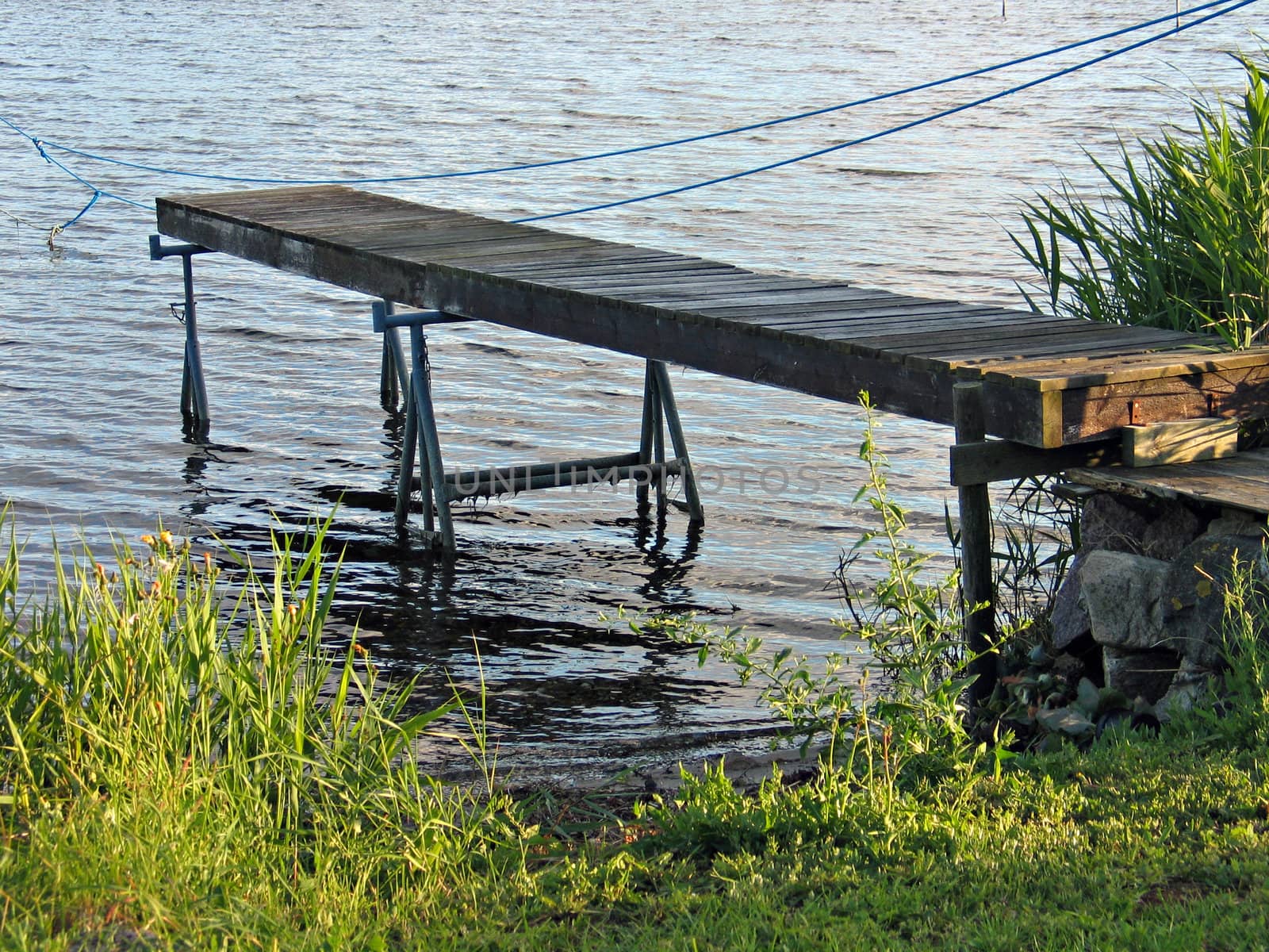 Small homemade wooden jetty dock in front of the water