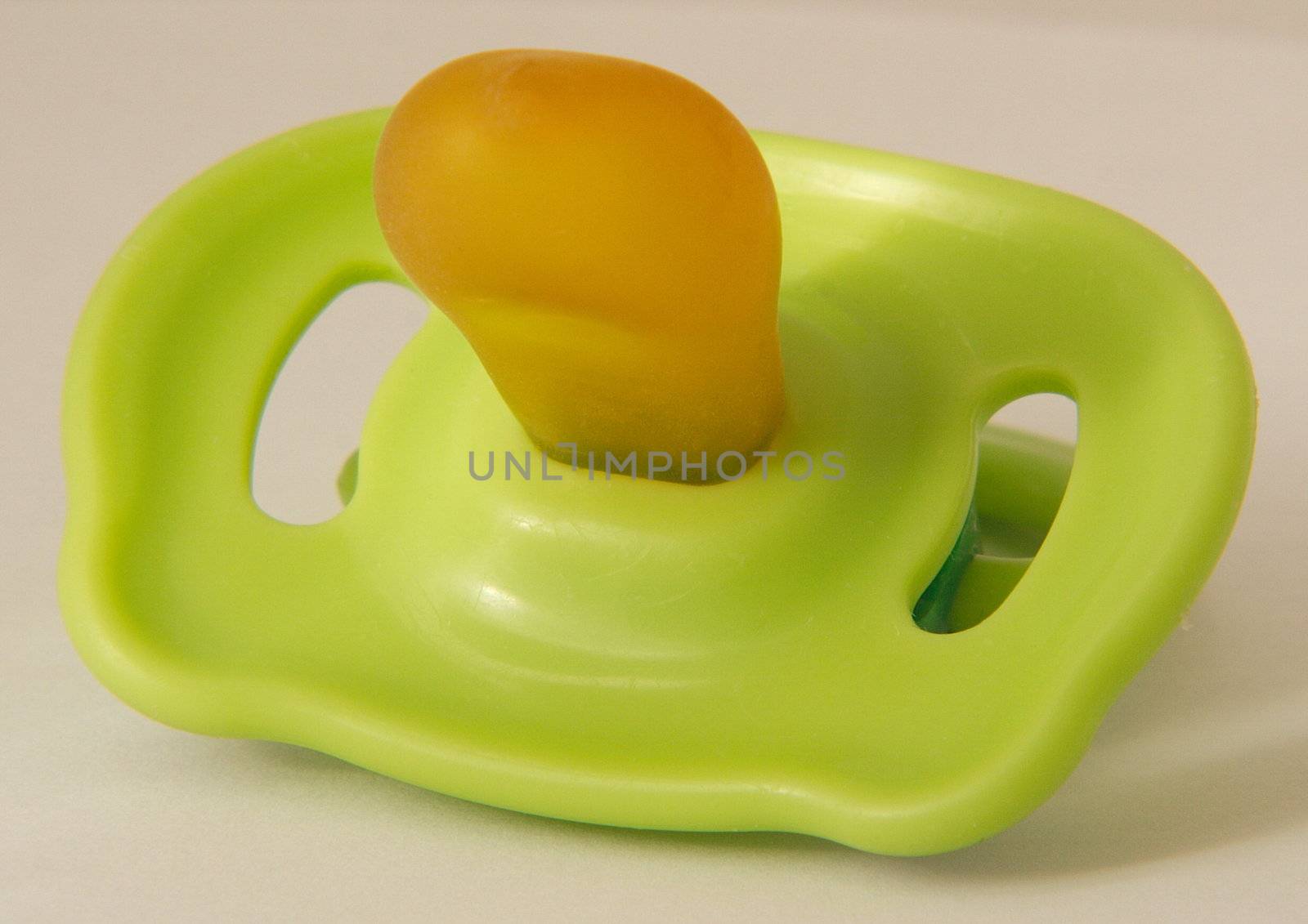 green plastic dummy for a baby or child