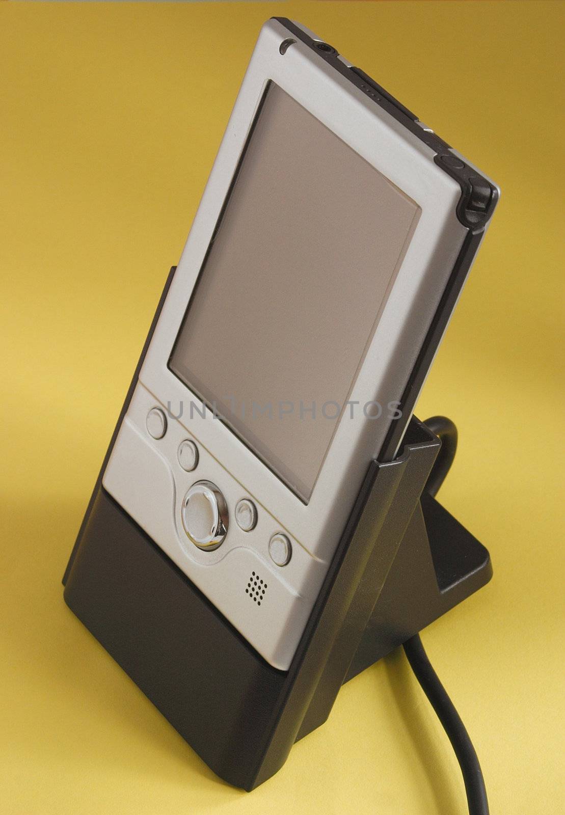 small silver palmtop pc in its charger