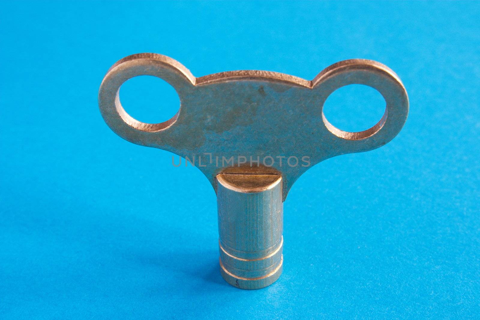 macro shot of a metal radiator key over a blue background