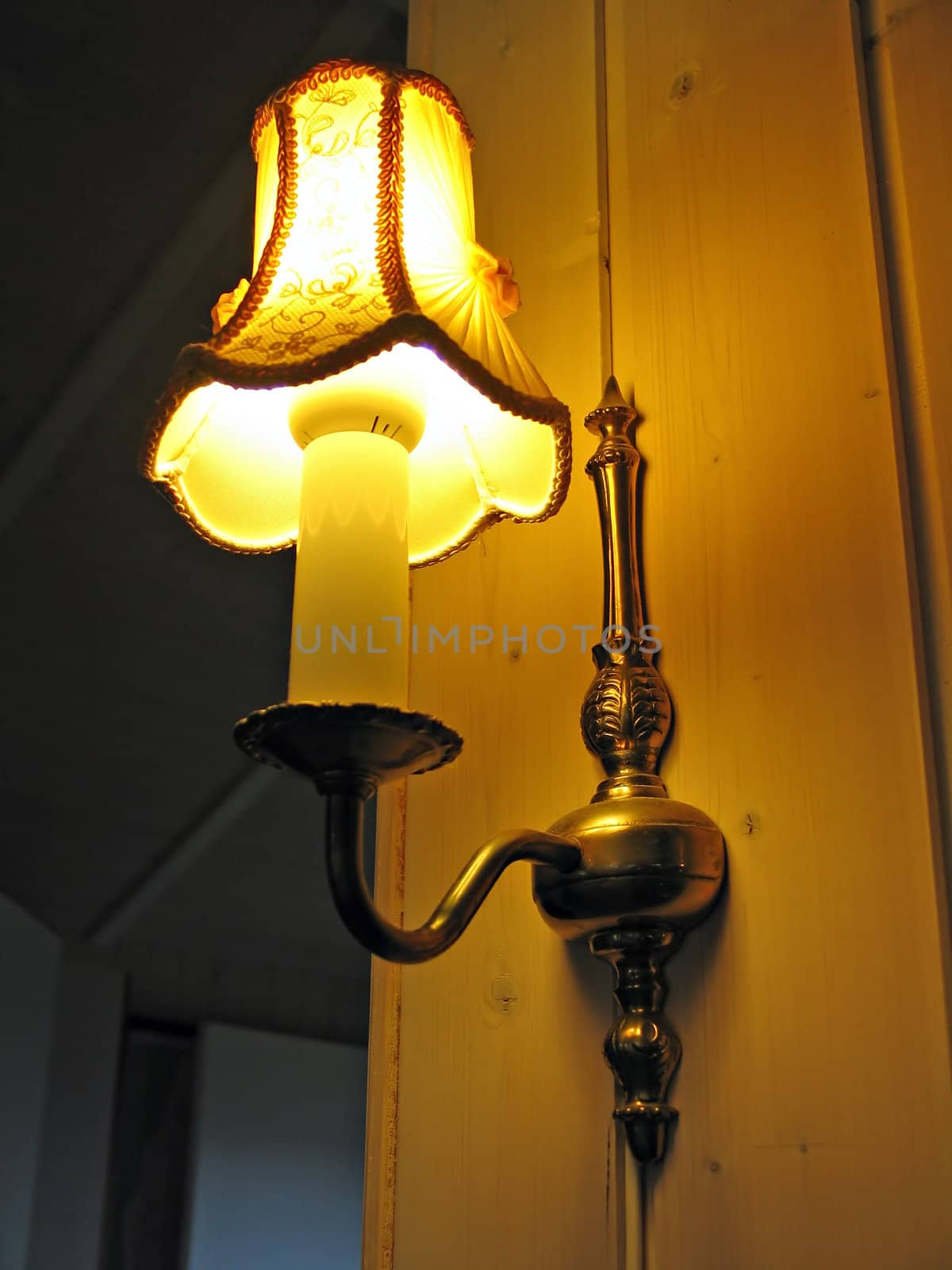 Classical design decorative wall lamp connected to a wood paneling wall