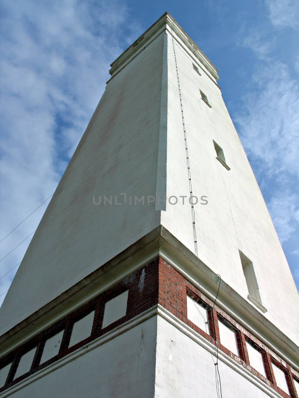 Perspective view of a tall white lighthouse