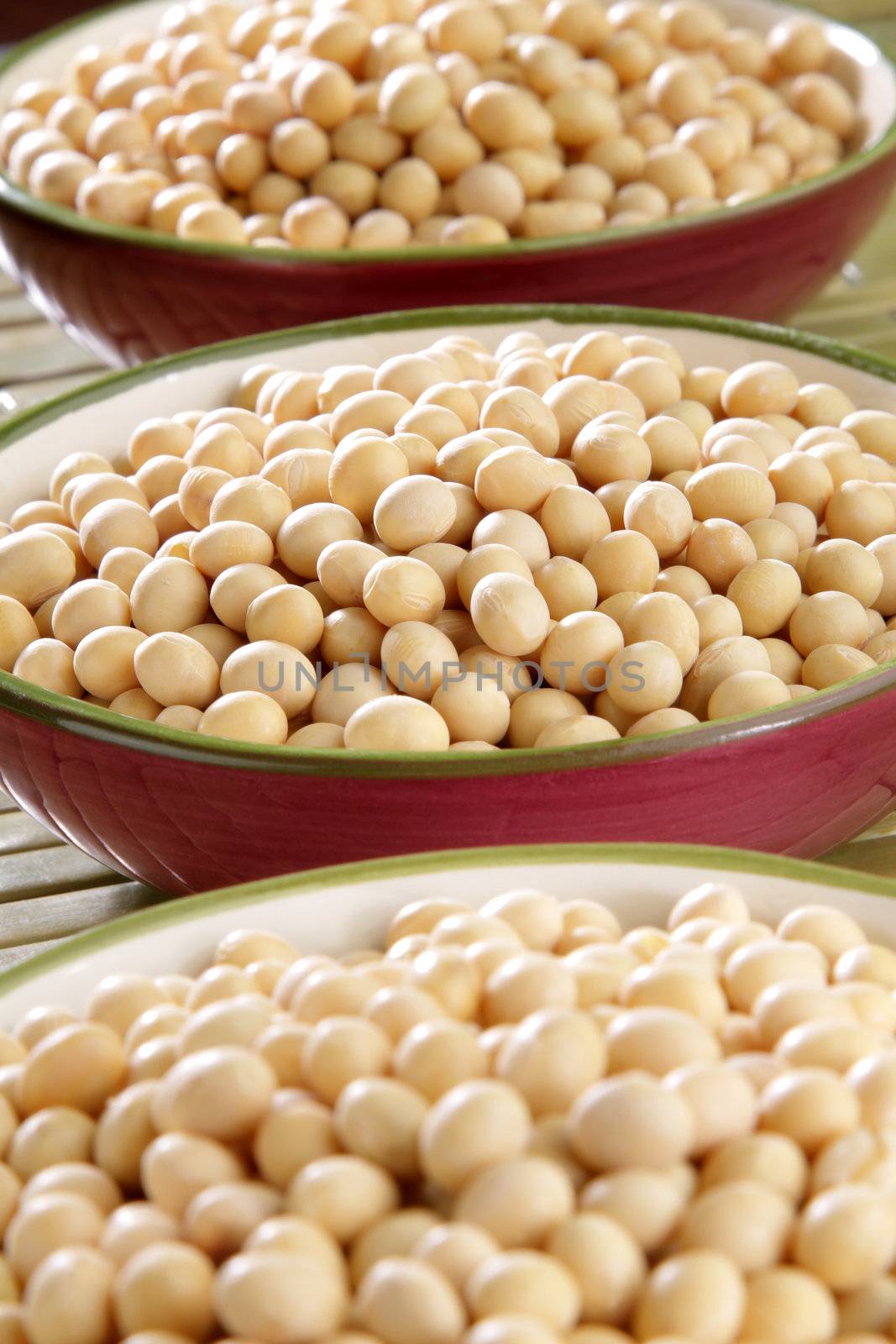 Several bowls of healthy organic raw soybeans.