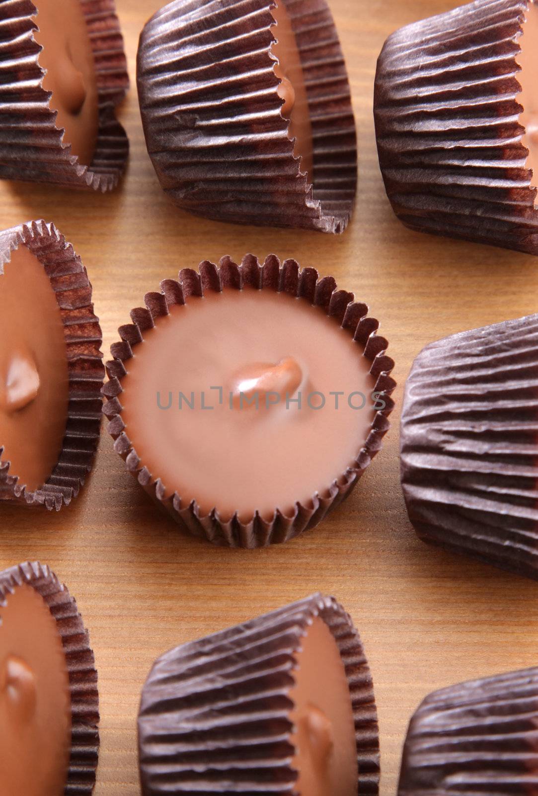 A group of peanut butter cups on a wood counter top.