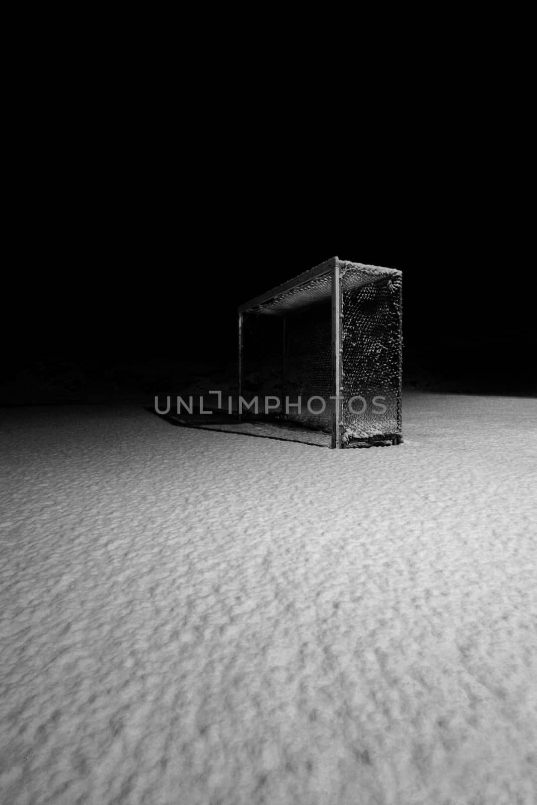 NIghtscene of a deserted soccerfield after a blizzard