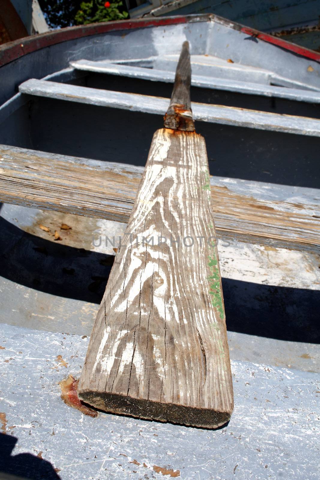 Old row boat with a worn oar.