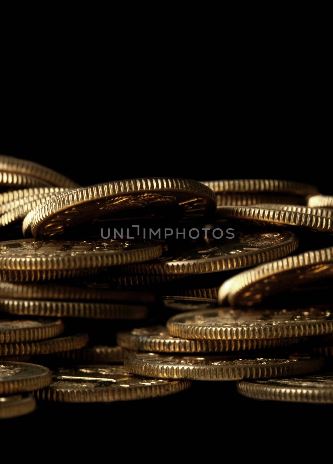 Macro of golden coins piled up with copy space below and above