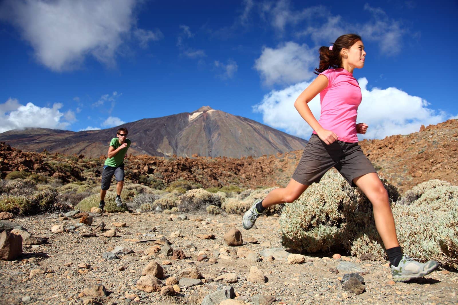 Couple trail running in spectacular volcano landscape on Teide, Tenerife. 