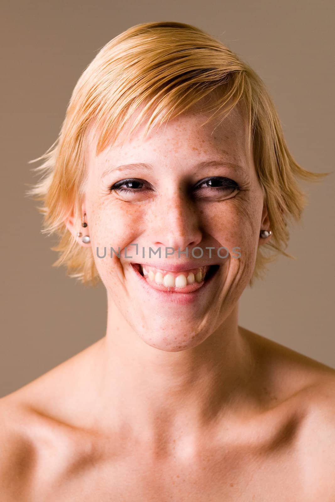 Studio portrait of a short haired blond girl clearly having fun