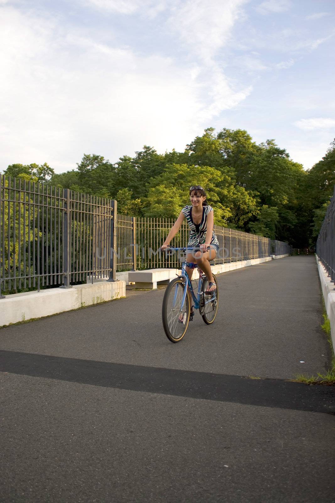 A young woman riding her bike outdoors.