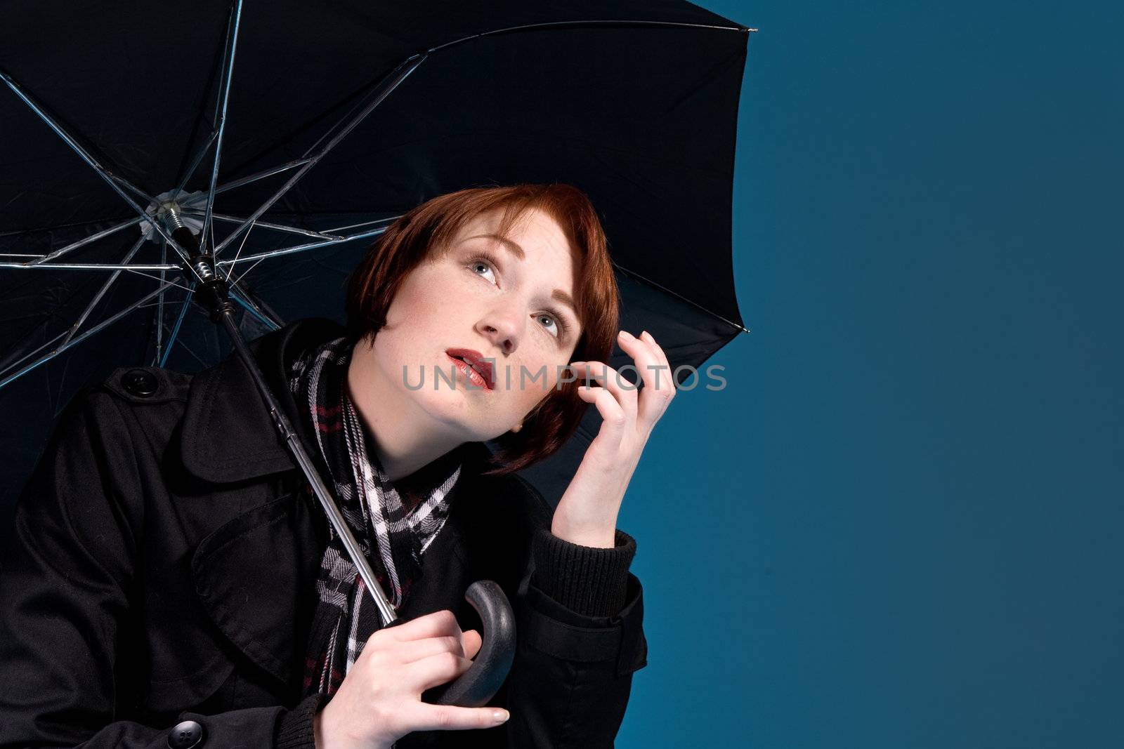 Young red haired girl with her umbrella