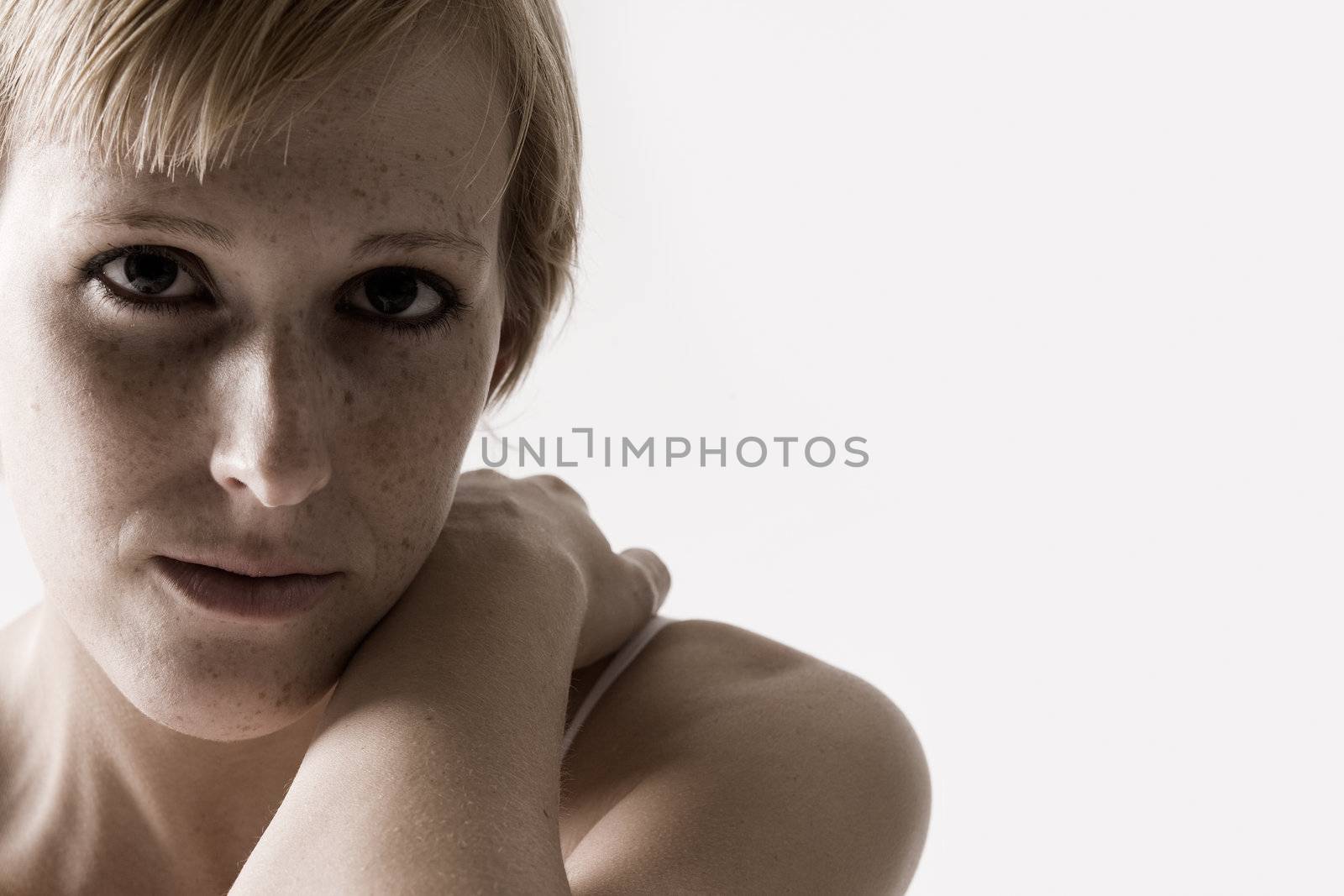 Studio portrait of a blond short haired girl looking sad