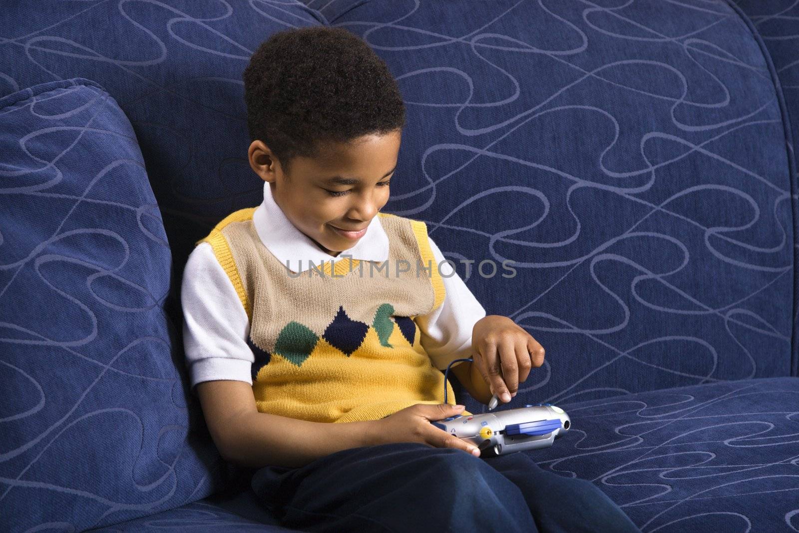 Boy playing video game. by iofoto