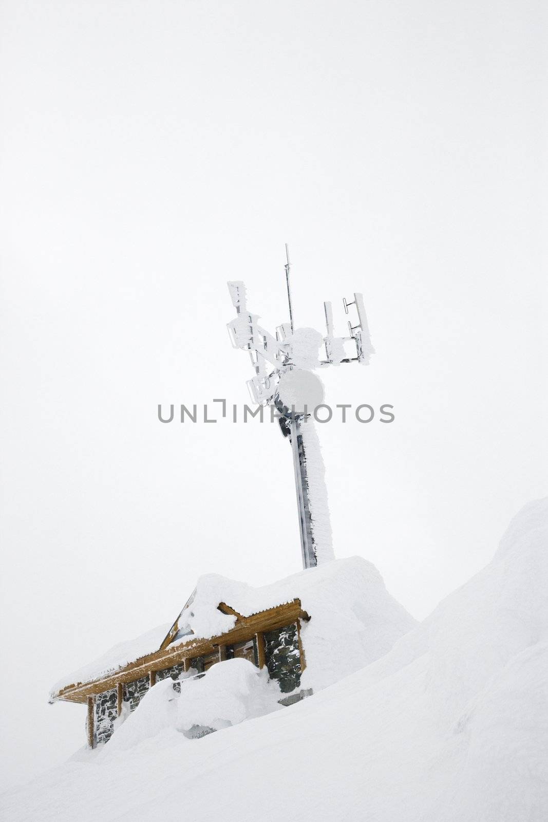 Cabin and antenna covered in snow.