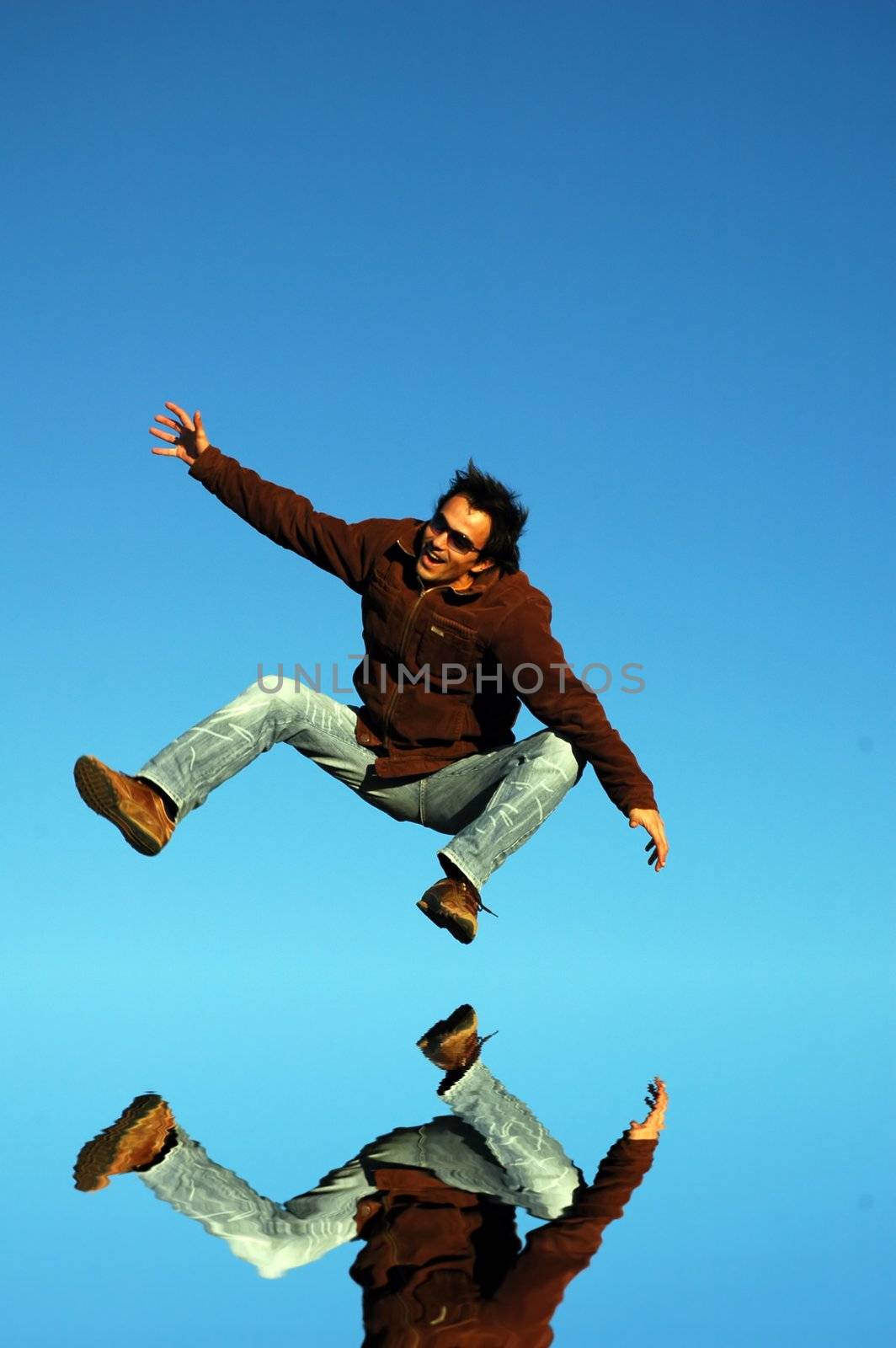 young man jumps high with water reflection