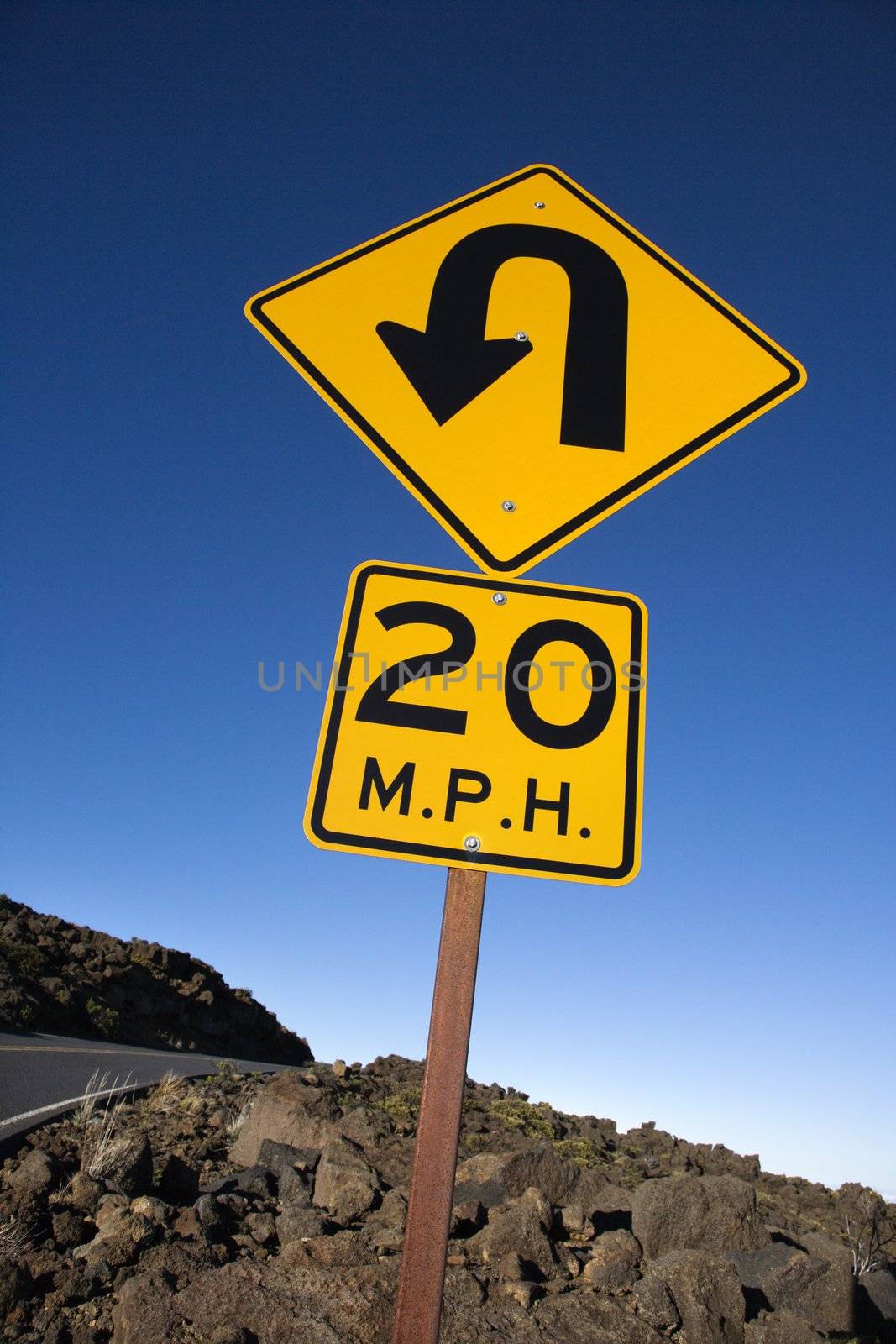 Warning road sign indicating curve and speed limit in Haleakala National Park, Maui, Hawaii.