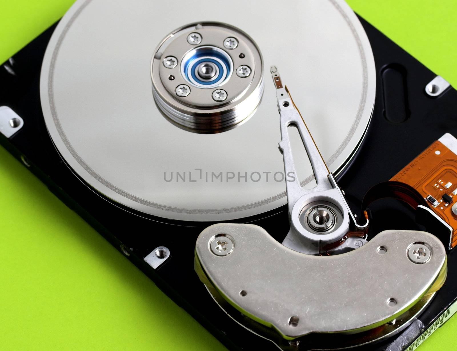 Open hard disk drive in a green background
