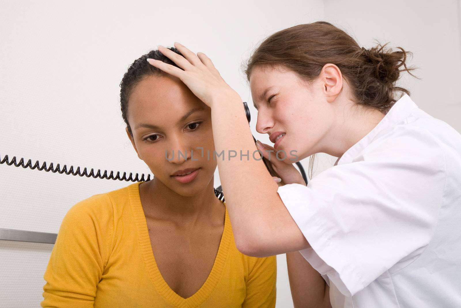 Doctor looking into the ears of her patient