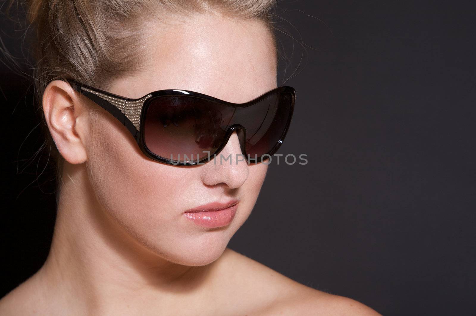 Beautiful woman with sexy sunglasses on black background