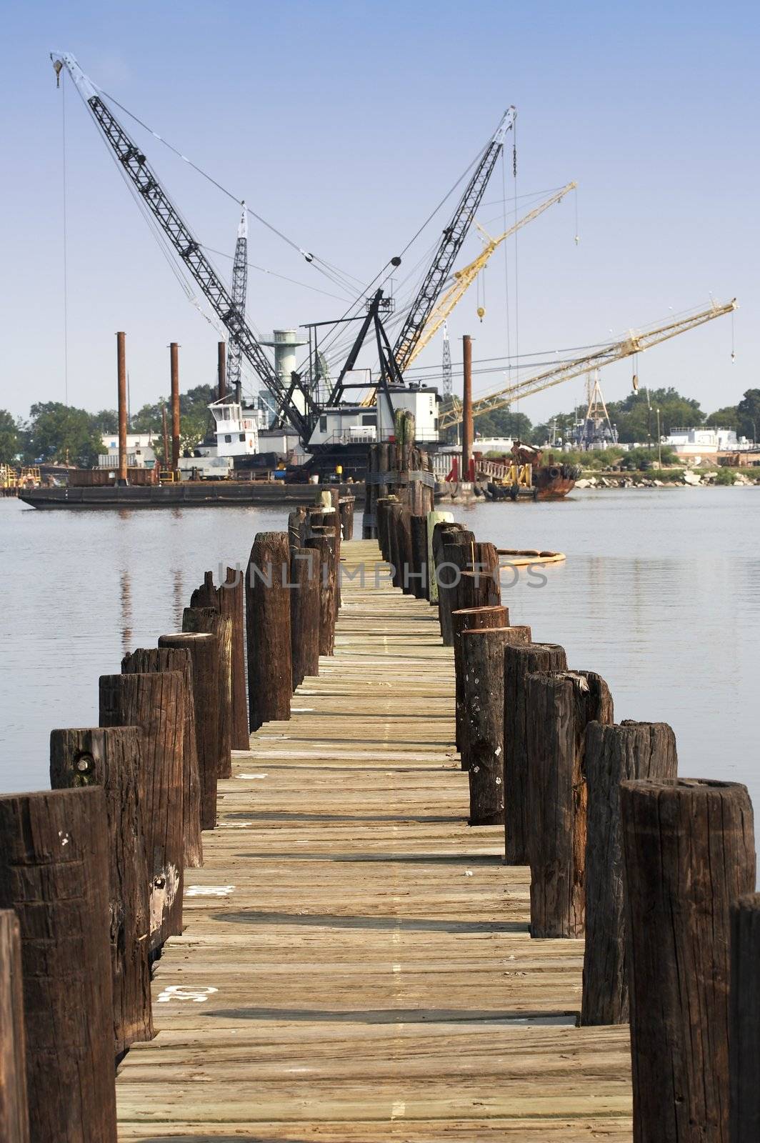 a pier view of floating cranes on the water