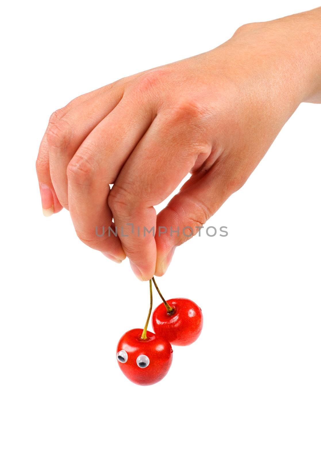 Female hand holding two sweet cherry with eyes