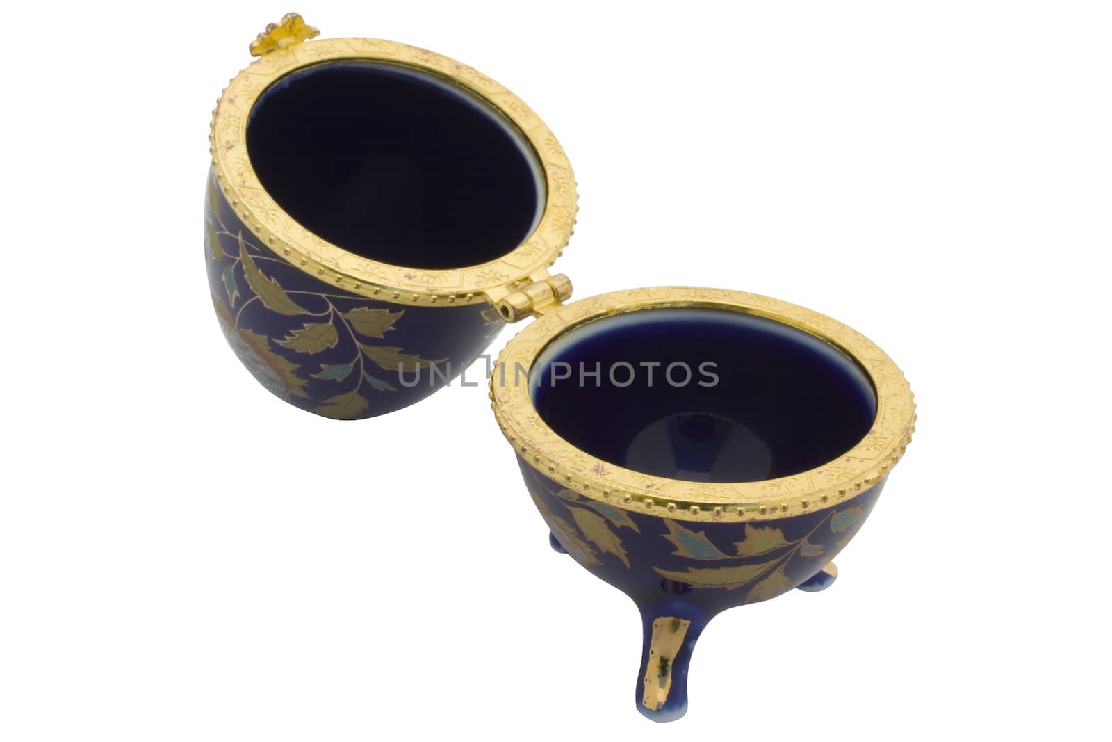 Opened ceramic casket as eggs faberge dark blue color with gold furnish it is isolated on a white background.