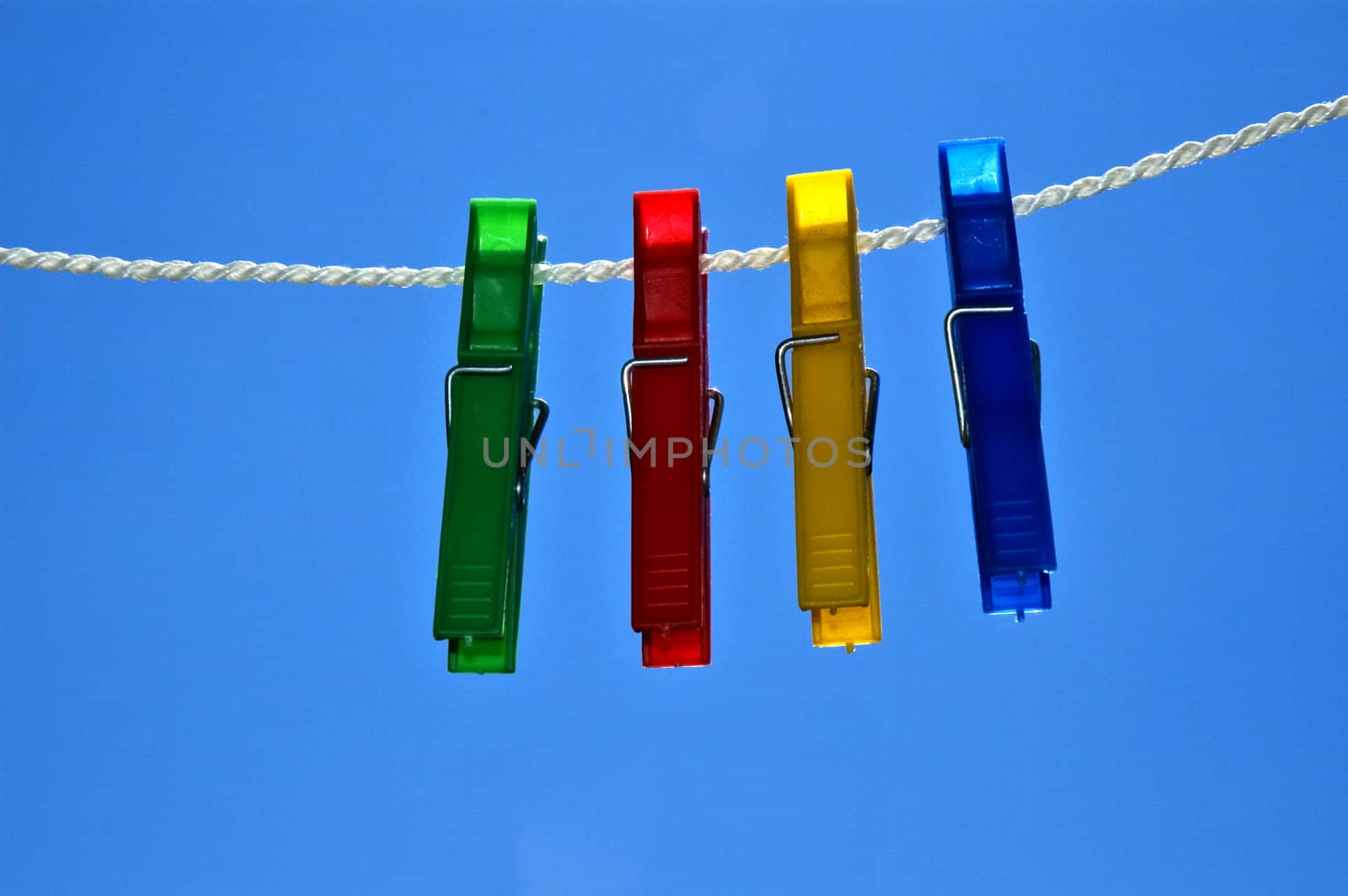 Green, red, yellow and blue clips on rope.