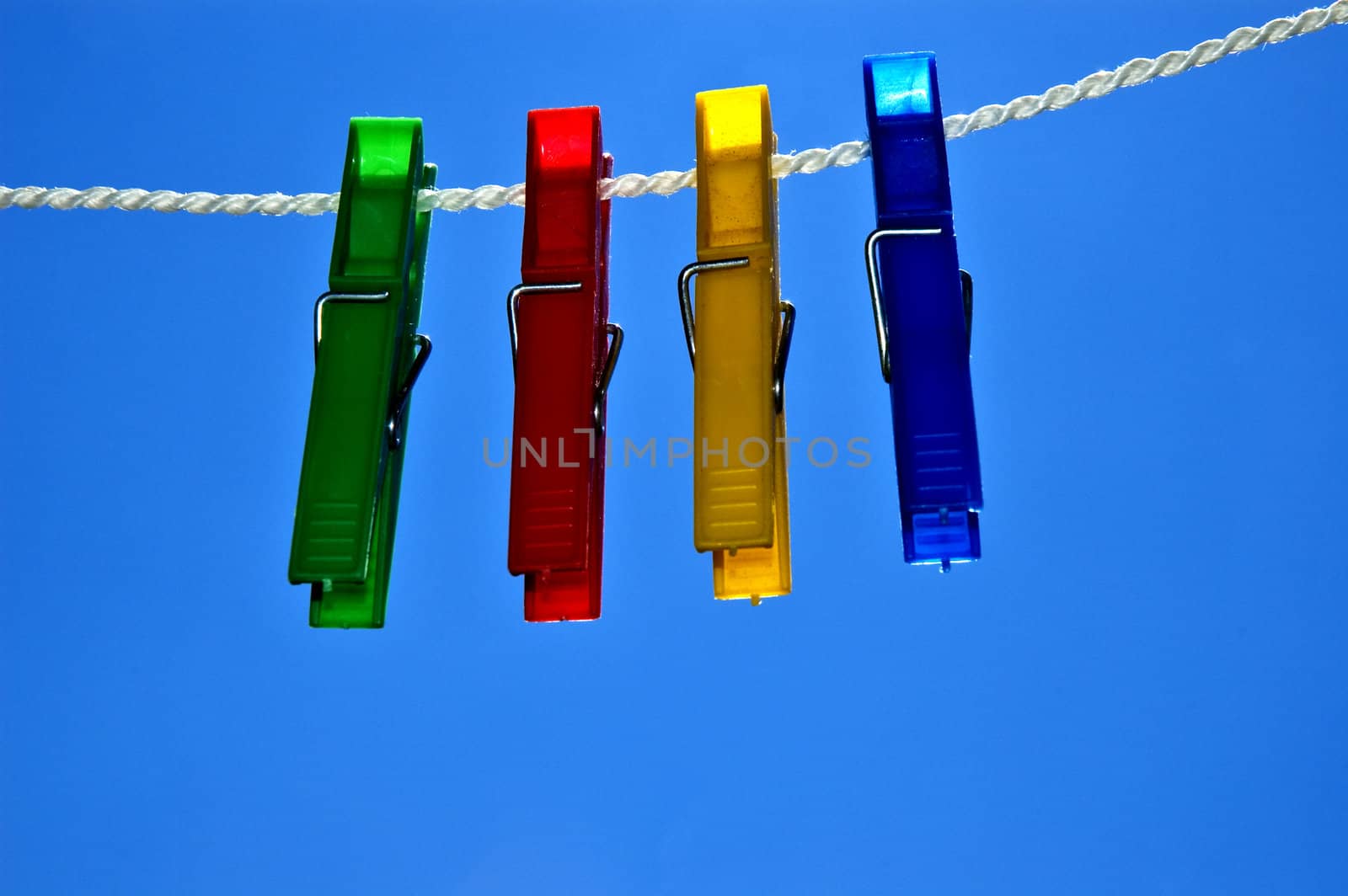 Green, red, yellow and blue clips on rope.