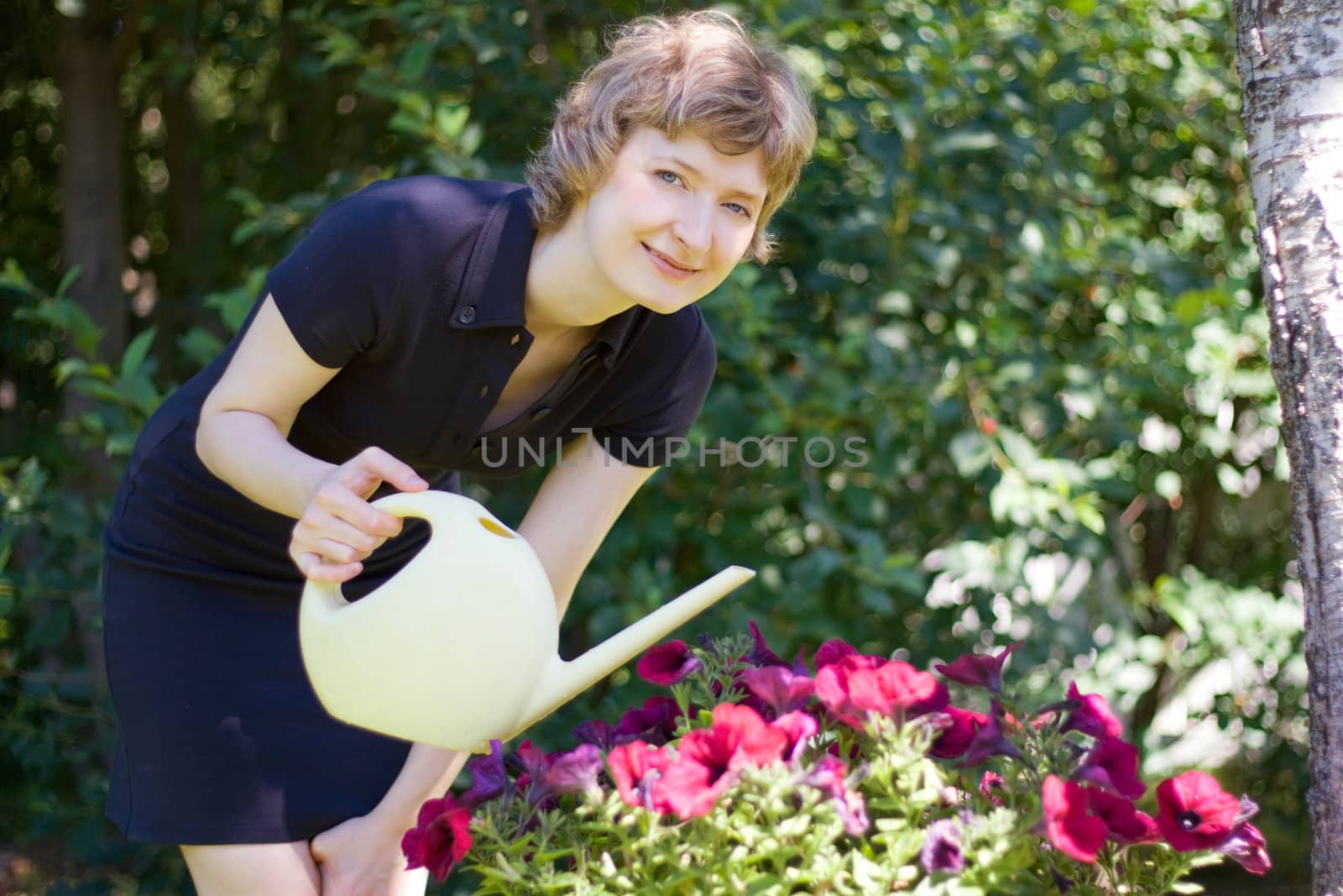 woman watering flowers, shot outdoors