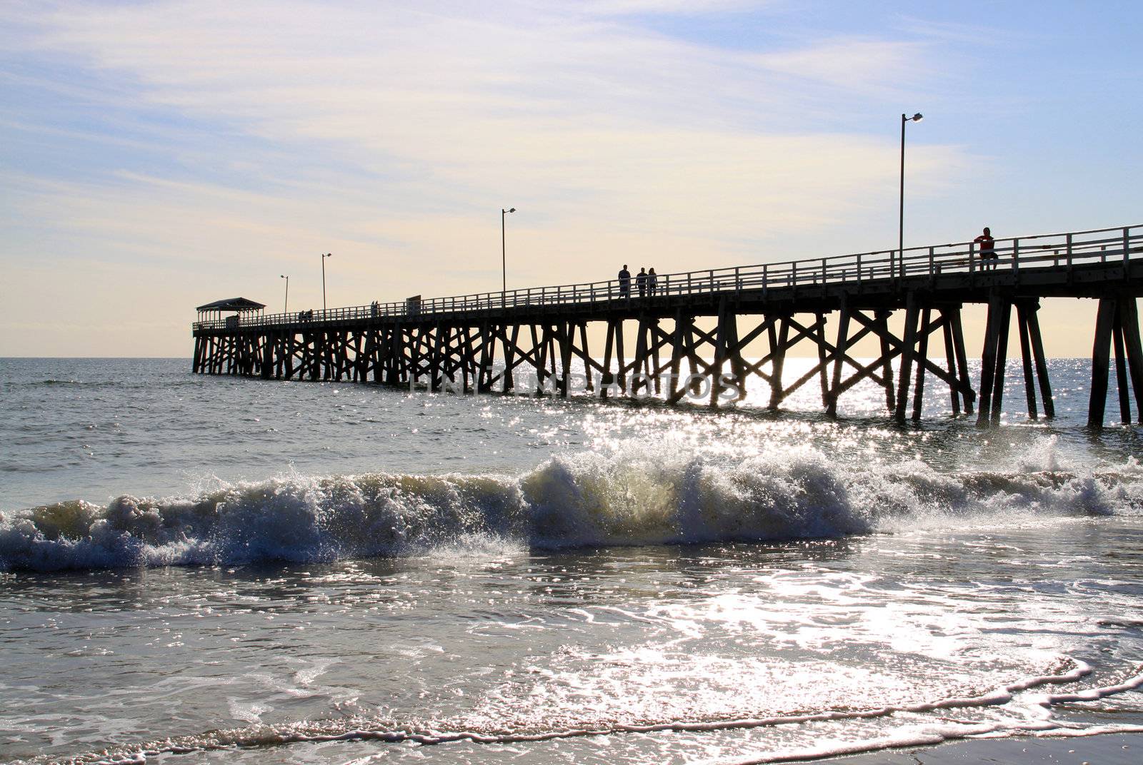 People walking along Grange Jetty before Sunset.  Grange beach, Adelaide, Australia