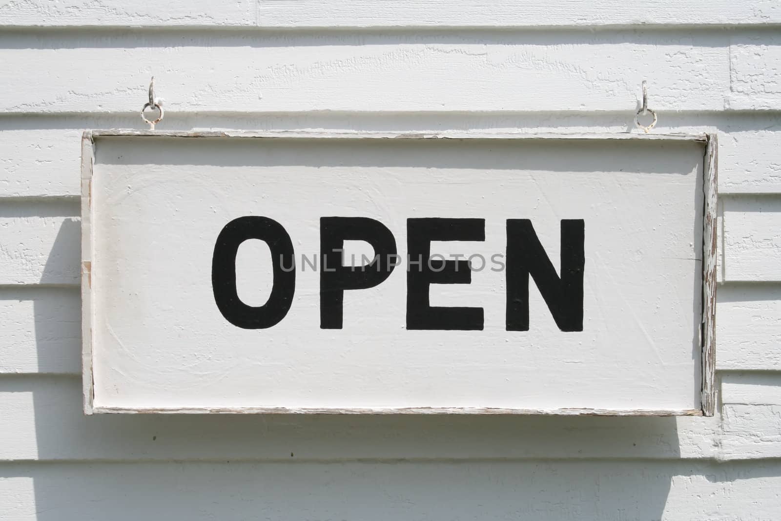 A welcoming old Open sign, black letters on white background