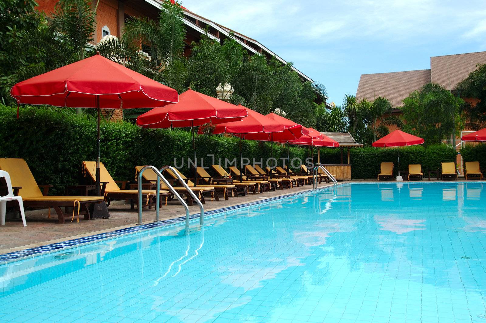 trestle-beds and red umbrellas near the resort's pool