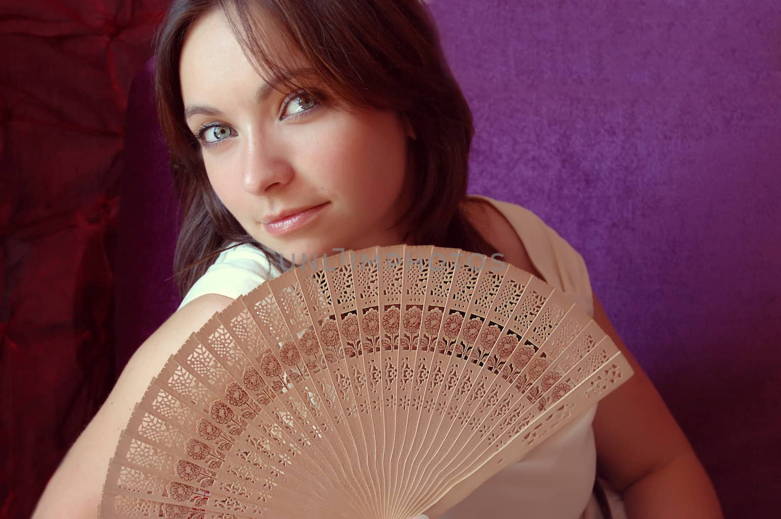 woman with opened fan on violet background
