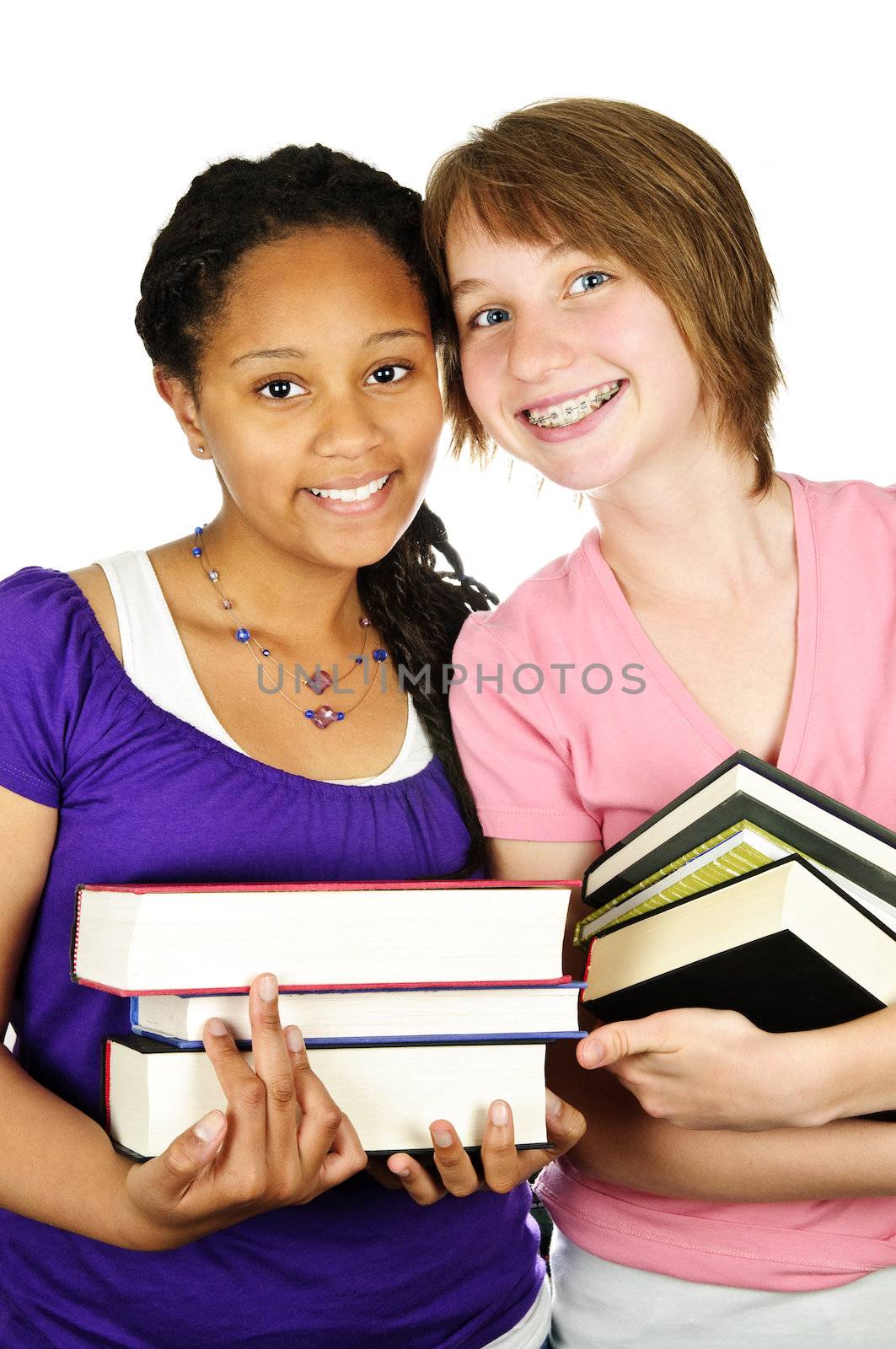 Isolated portrait of two teenage girls holding text books