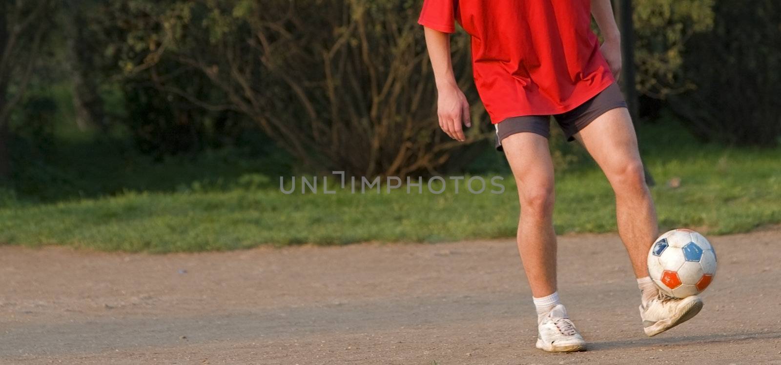 A football player's legs skilfully juggling with a ball. A lot of copy space on the left.