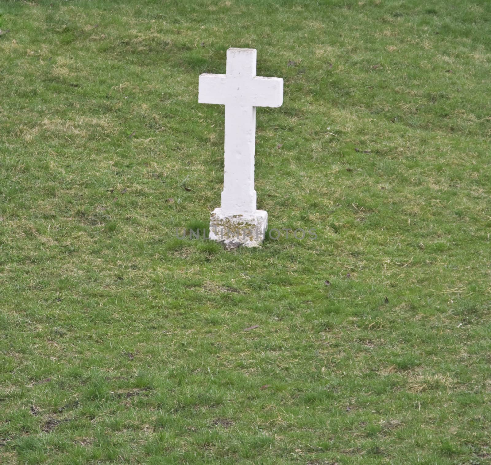 A white cross in a green grass field.