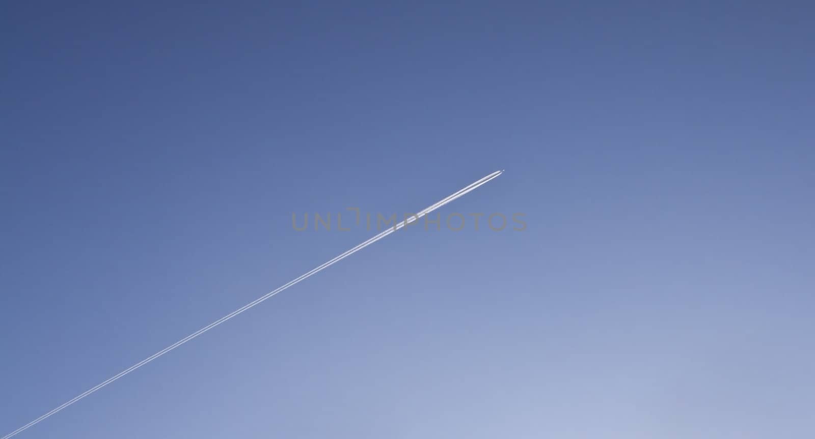 Image of airplane traces on a dark blue sky.