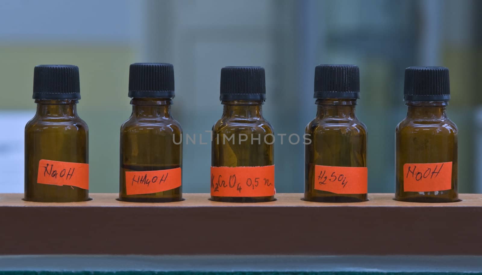 Row of brown laboratory bottles with innorganic substances.