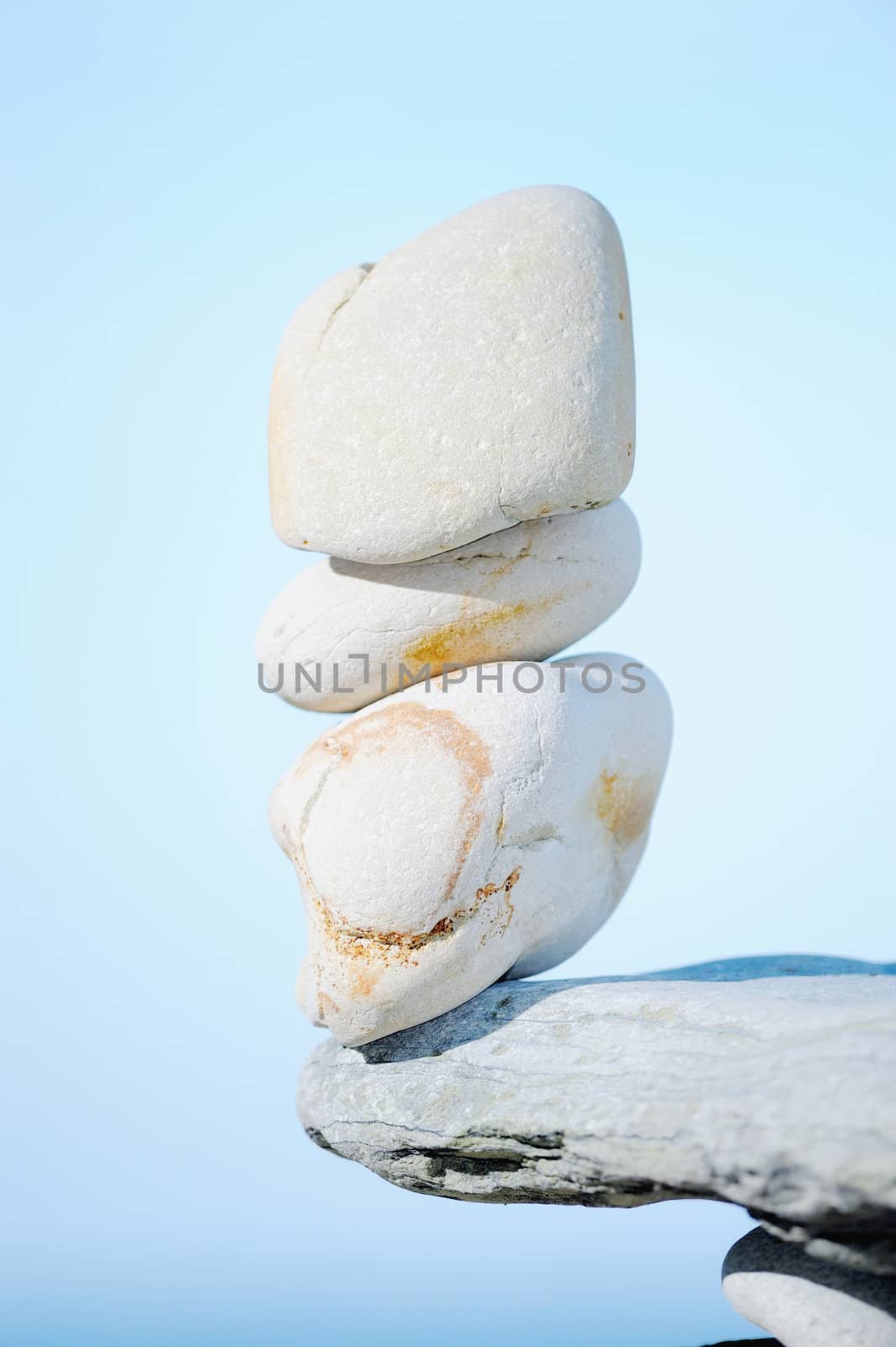 A pile of a white pebbles on the brink of boulder