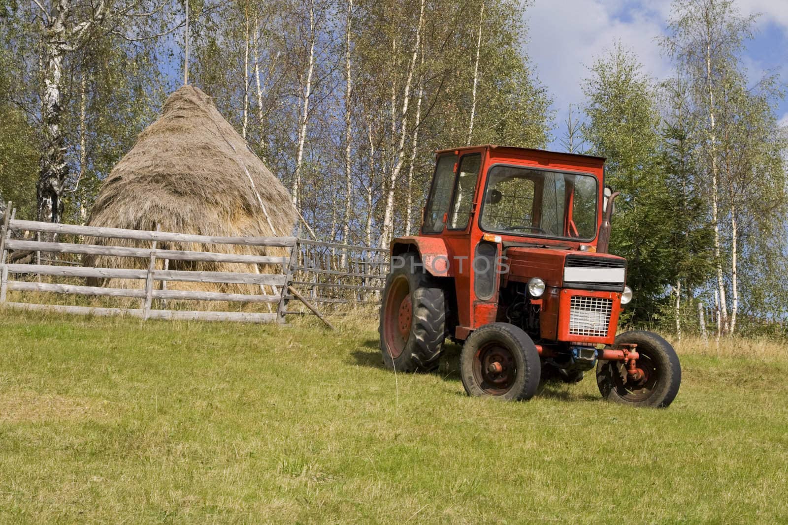 Image of a tractor in a mountain rural area.