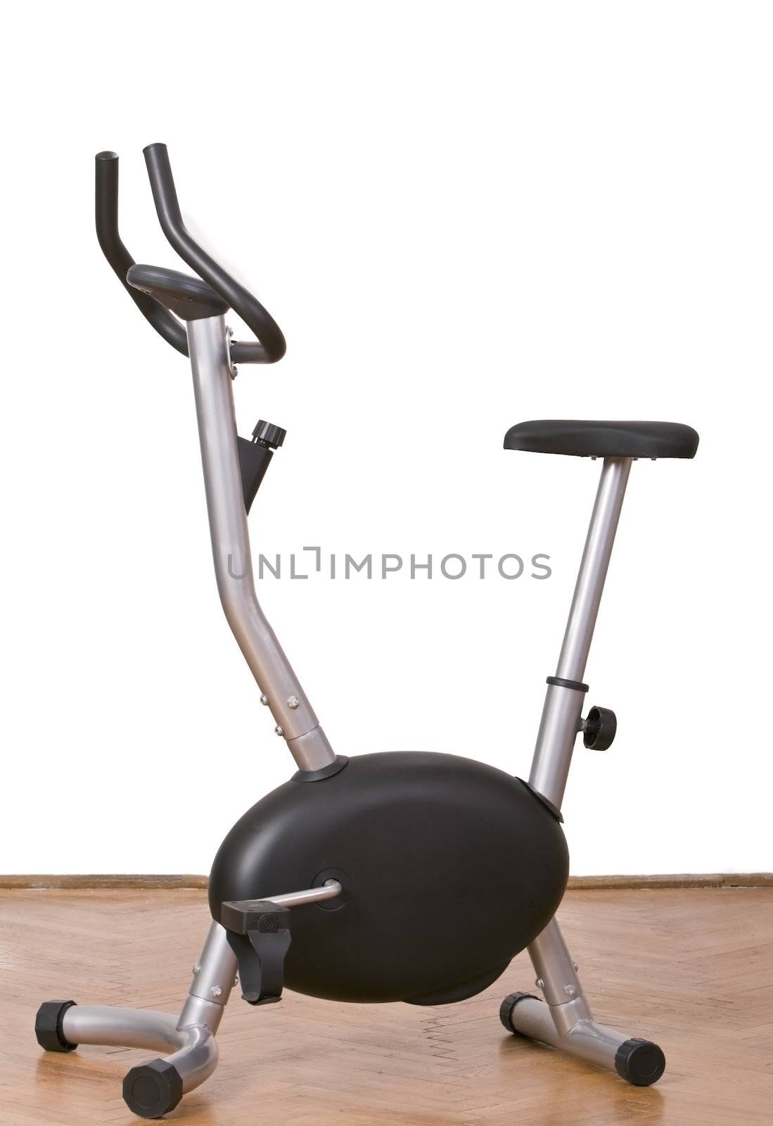 Fitness bicycle on a parquet floor in a gym.