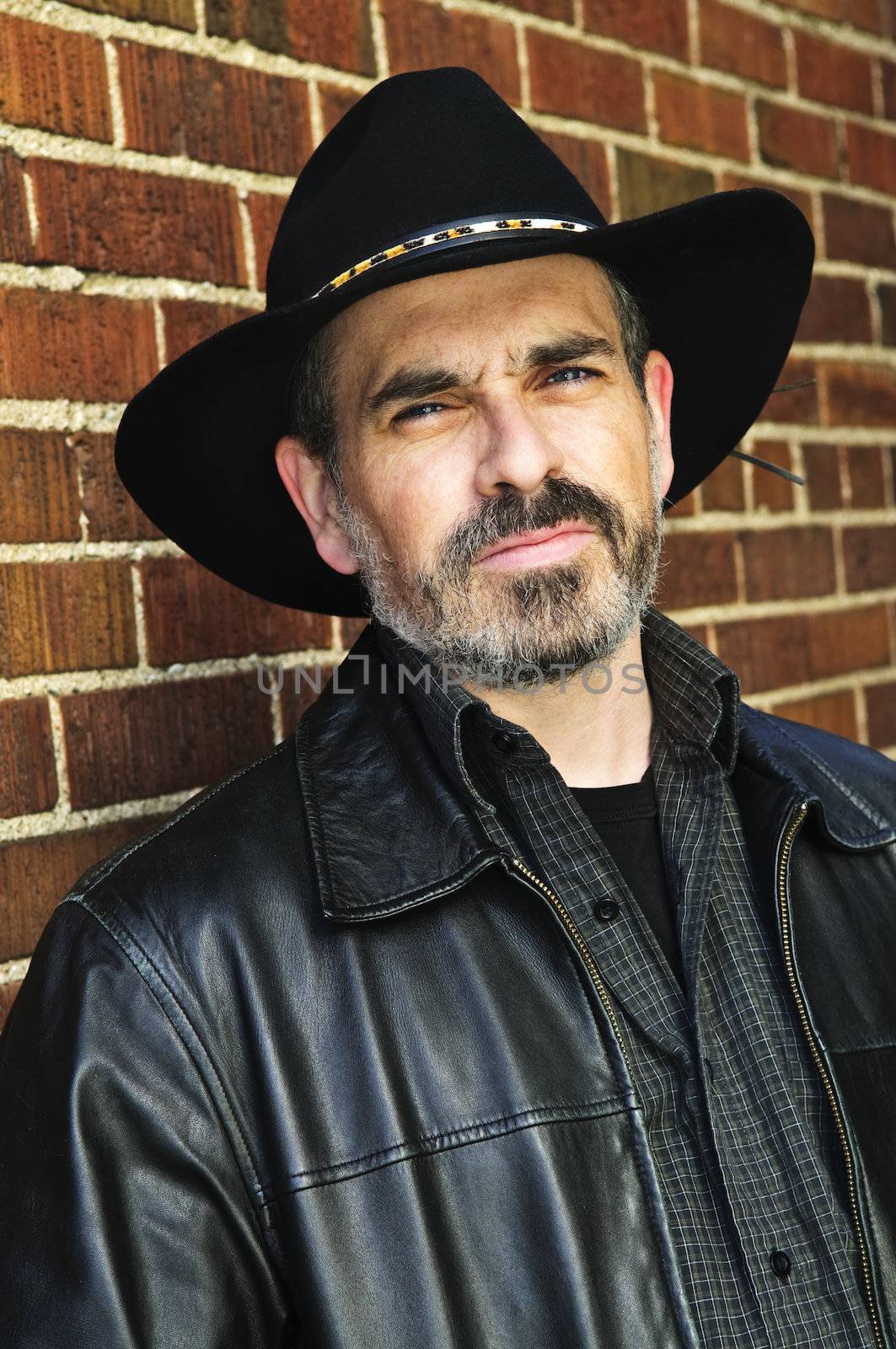 Man with beard in cowboy hat and leather jacket