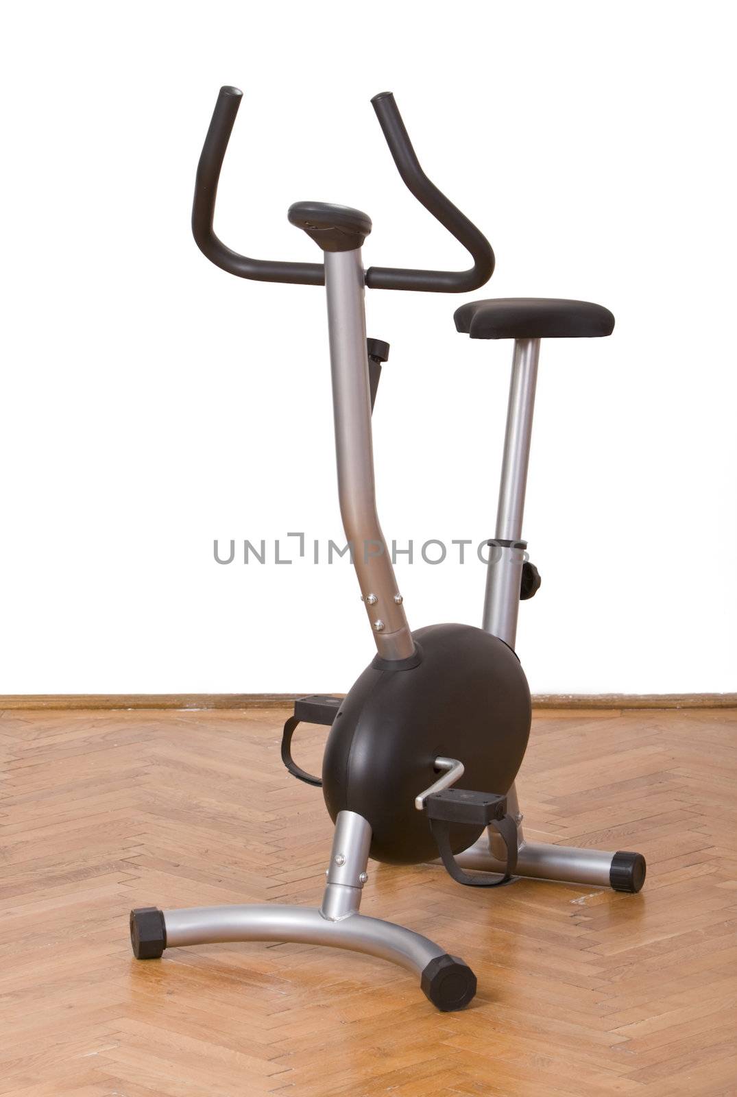 Fitness bicycle on a parquet floor in a gym.