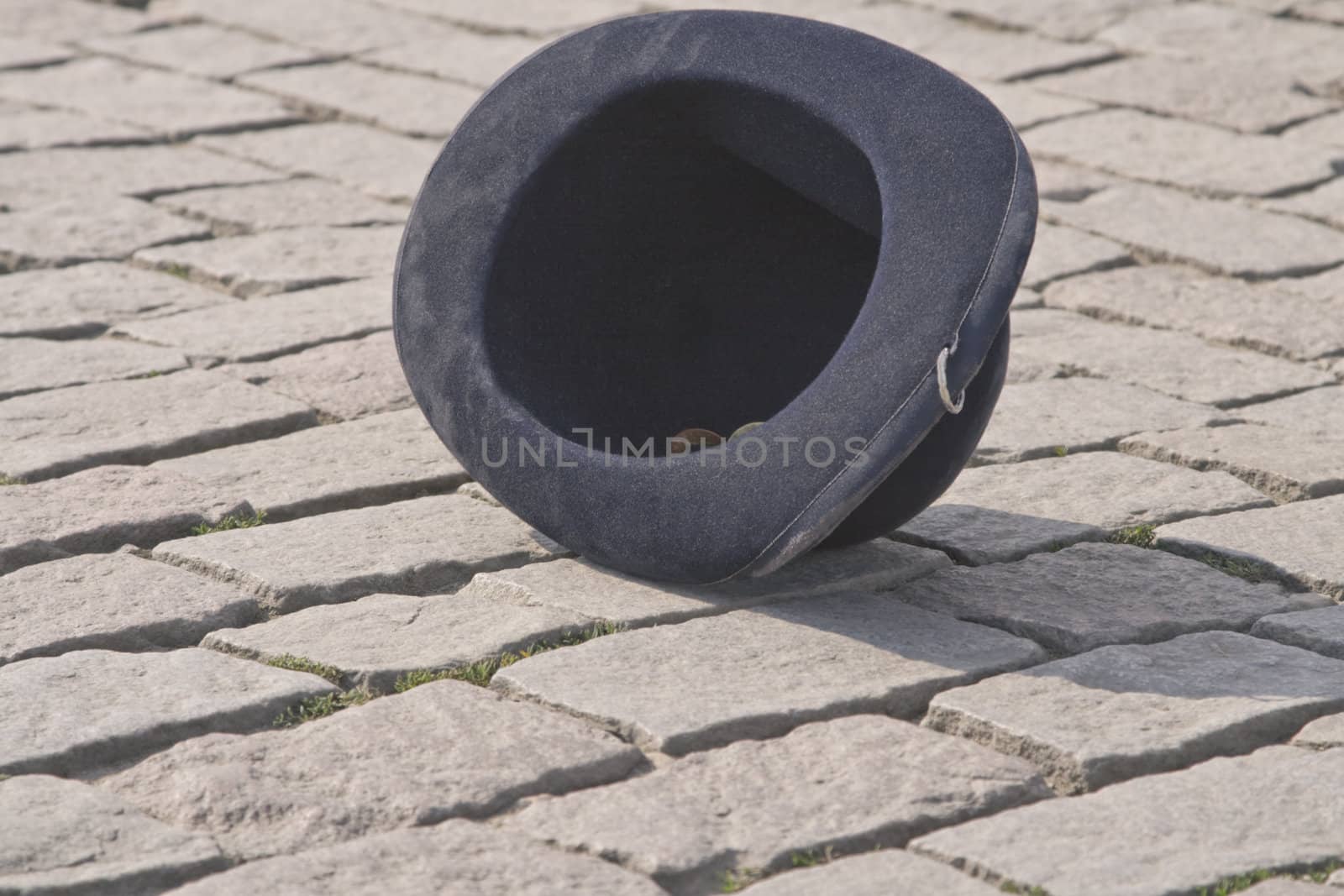 Street artist's black felt hat used for collecting funds in a pavement street. Location:Charles Bridge,Prague.