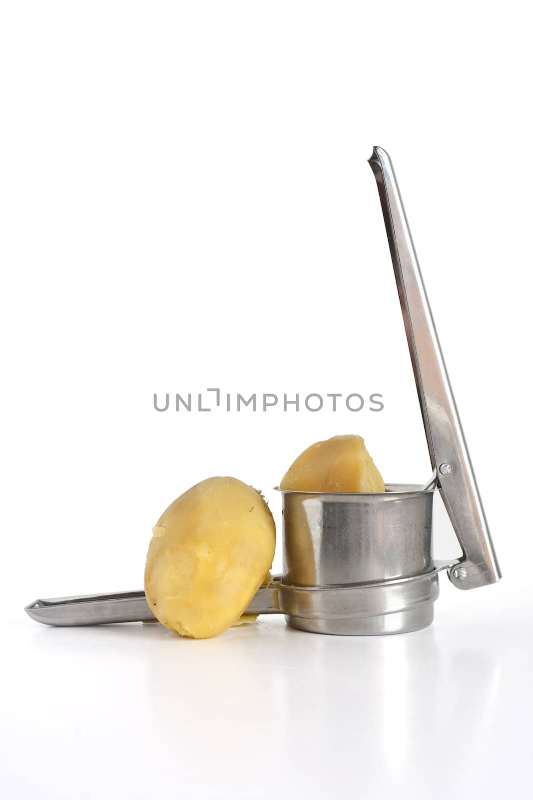 closeup of potato masher with two boiled potatoes isolated on white background with clipping path