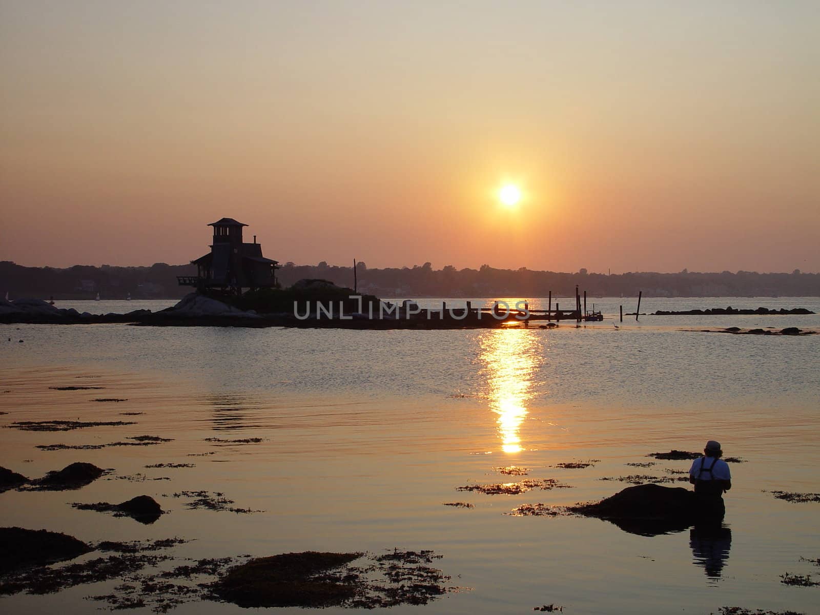 A fisherman enjoys an evening of fishing on the river.