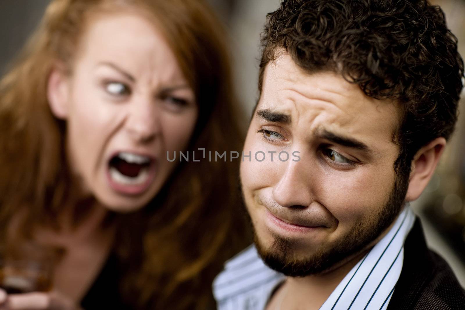 Young woman with cocktail yells at a man at party