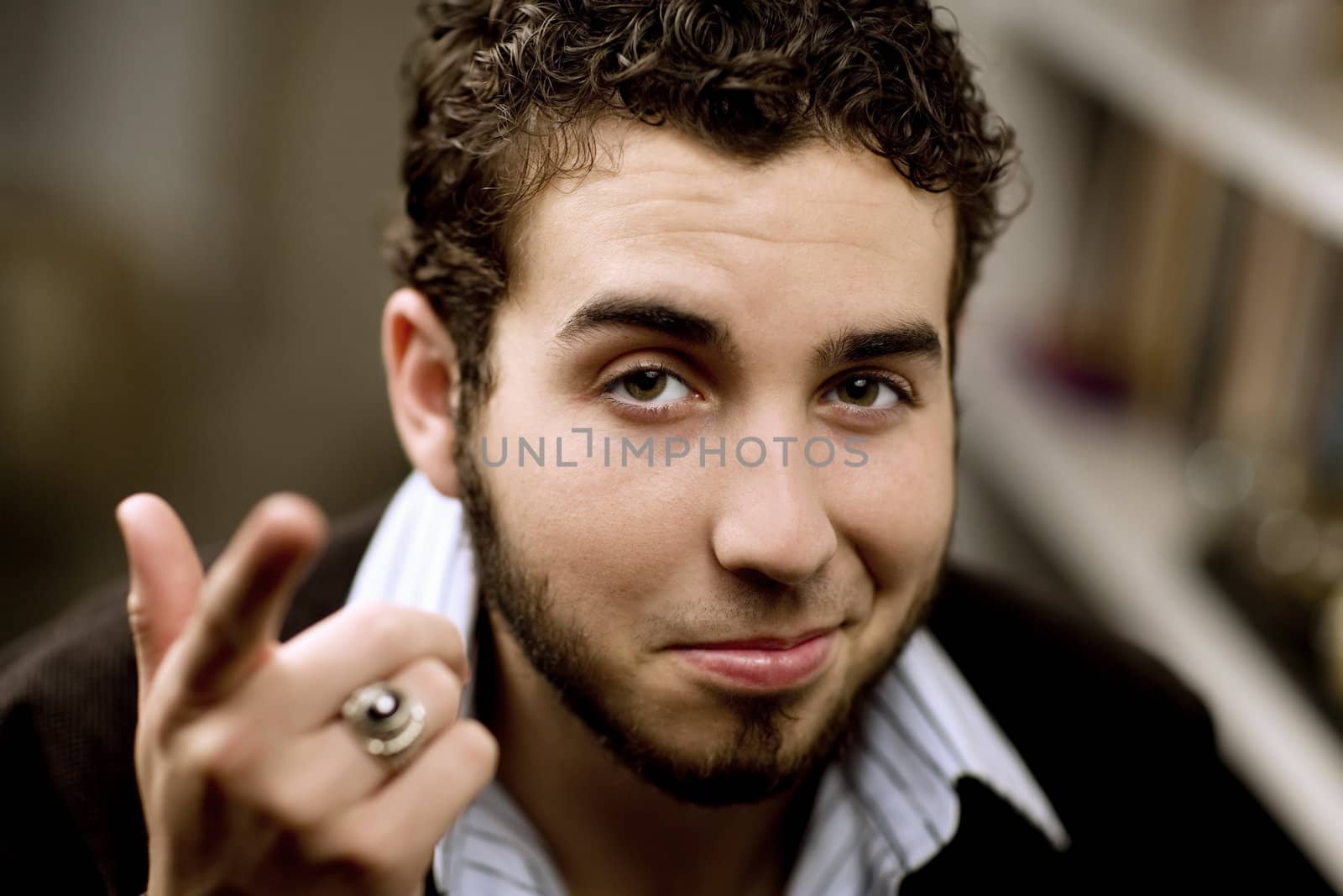 Portrait of handsome young man with beard gesturing with his hand